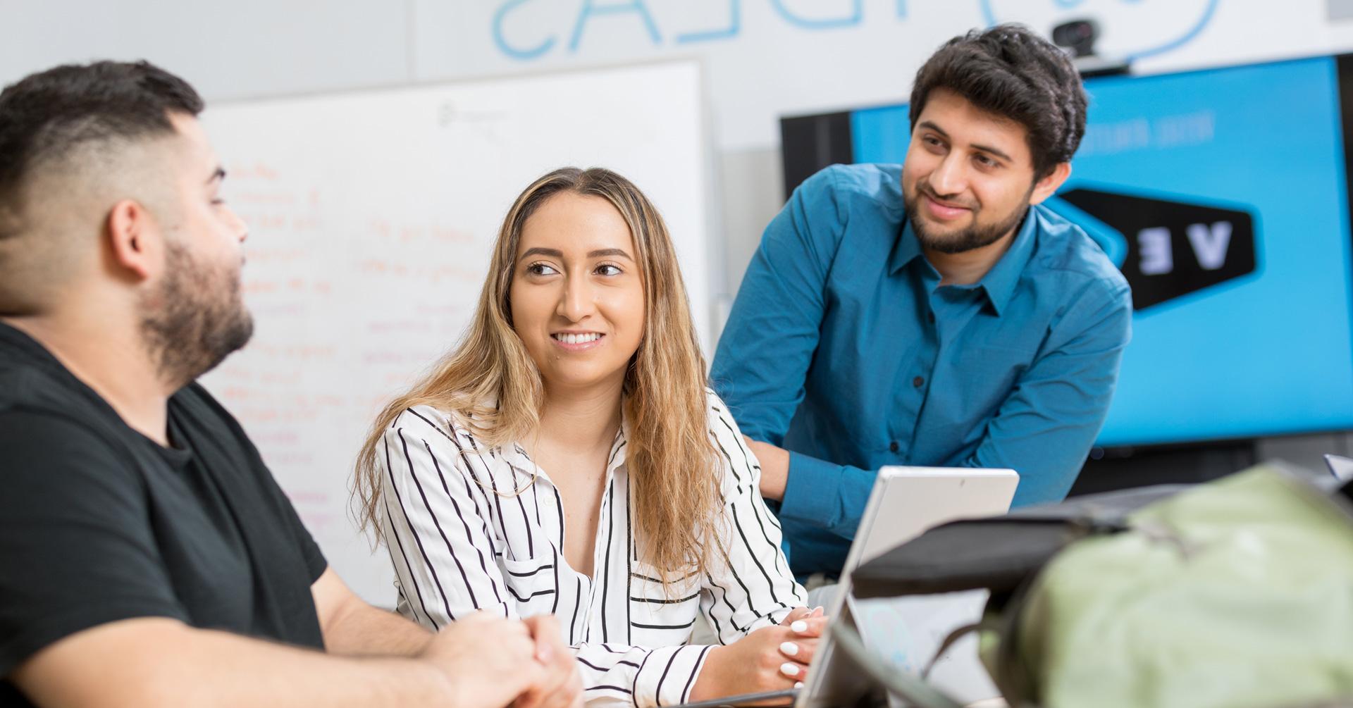 Students gather around at a table in the IDEAS lab.